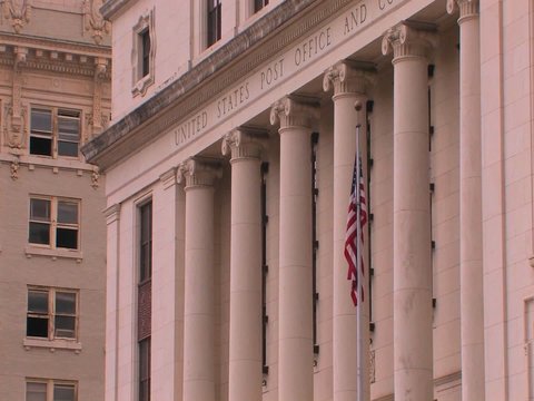 A flag blows in a breeze at the United States Post Office.