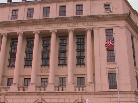 A flag blows in a breeze at the United States Post Office and Court House.