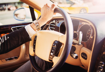 Behind the wheel. Man driving luxury expensive car.