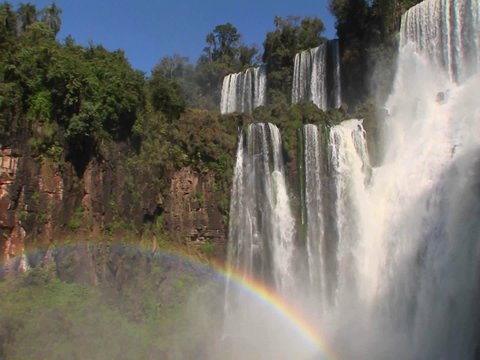 Iguacu Falls with rainbow in foreground.