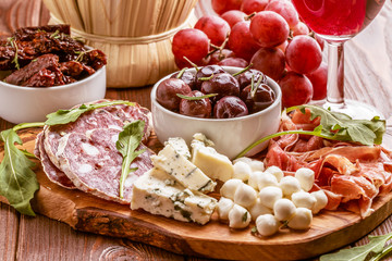 Wine snack set. Variety of cheese and meat on dark background.