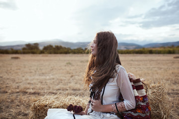 Tourist girl enjoying view of beautiful dry golden wheat hills