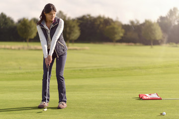 Golfer puttet einen Ball zum Loch