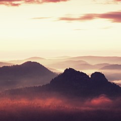 Tourist resort in Saxony. Fantastic dreamy sunrise on the top of the rocky mountain with the view into misty valley
