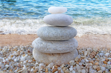 Fototapeta na wymiar Stack of zen stones on beach and wave background