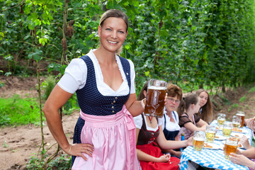 Fototapeta premium Frauen im Dirndl und Bier und Hopfenfeld Hintergrund Porträt