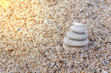 Fototapeta na wymiar Stack of zen stones on beach background with burning sun