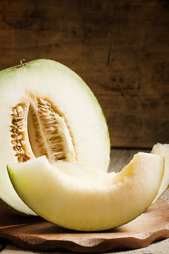 cut melon and slices on a wooden table, selective focus