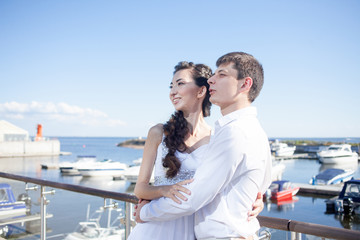 bride and groom on the background of  yacht club, young happy