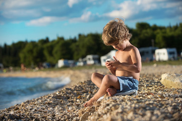 Fototapeta na wymiar Little boy playing with smart phone