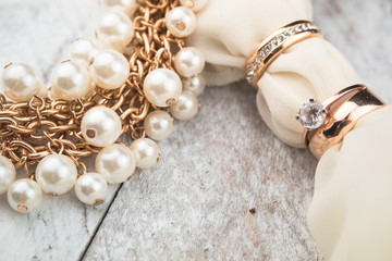 Golden wedding rings on white wood background