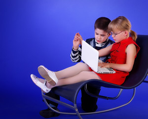 Дети за компьютером. Мальчик с девочкой сидят с...