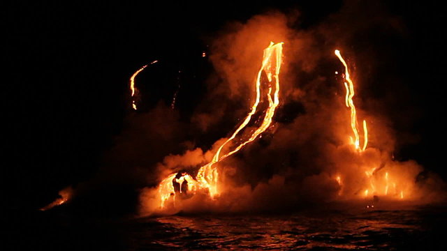 Spectacular nighttime lava flow from a volcano into ocean.