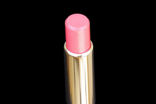 One open lipstick isolated on black background