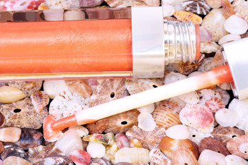 Lip gloss closeup on seashells background