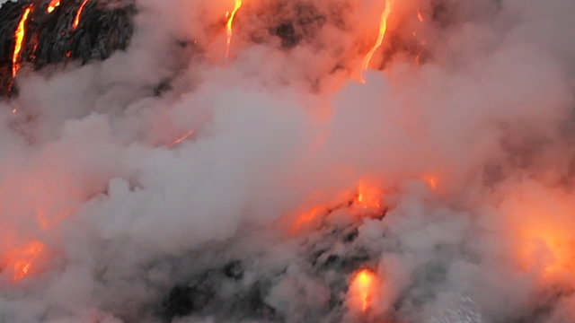 Spectacular dusk lava flow from a volcano into ocean.