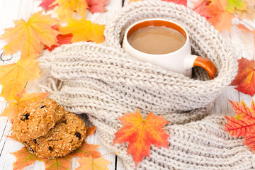 Cup of coffee and oatmeal cookies with autumn maple leaves