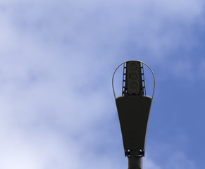 A lamp post from under with a blue sky in the background