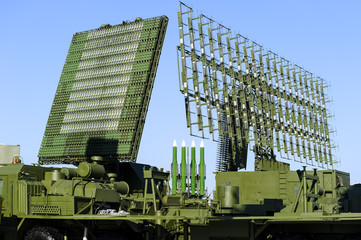 Air defense radars of military mobile antiaircraft systems in green color and ballistic rocket launcher with four cruise missiles in centre of frame, modern army industry 