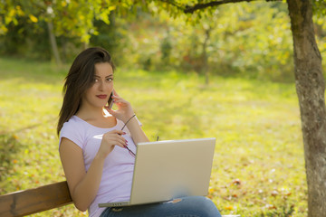 Young happy woman working in park