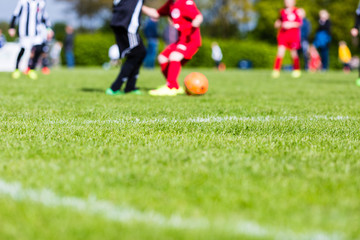 Obraz premium Blurred kids playing youth football match
