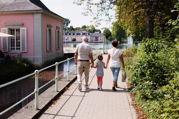 Fototapeta na wymiar Grandparents With Grandchildren walking together in the park