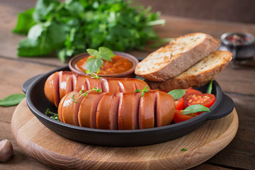 Sausages on the grill pan on the wooden background
