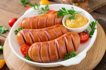 Sausages on the grill with mustard on a platter
