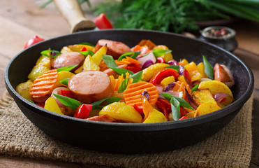 Fried potatoes with vegetables and sausages