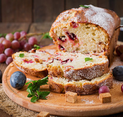 Juicy and tender cupcake with plums and grapes
