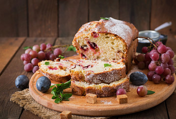 Juicy and tender cupcake with plums and grapes