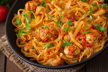 Pasta linguine with meatballs in tomato sauce.