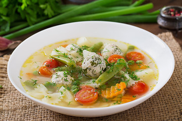 Diet vegetable soup with chicken meatballs and fresh herbs in bowl