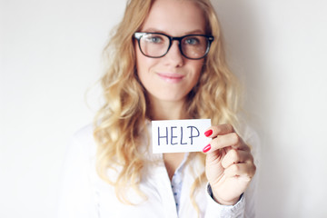 Young  blonde woman holding white card with 