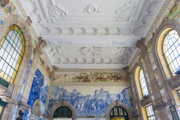Fototapeta na wymiar Painted ceramic tileworks on the walls of Main hall of Sao Bento Railway Station in Porto,Portugal