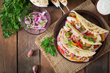 Fototapeta na wymiar Mexican tacos with chicken, grilled vegetables and red onion. Top view