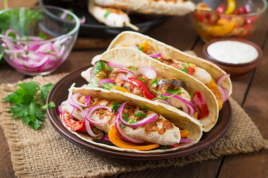 Mexican tacos with chicken, grilled vegetables and red onion.