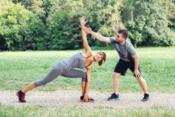 Personal trainer helps a woman during exercise