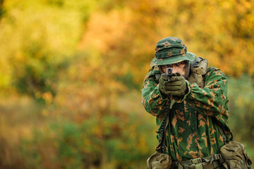 Fototapeta premium young soldier aiming and shooting with a pistol
