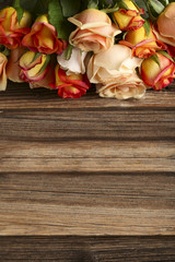 Bouquet of orange roses on brown wooden background