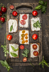 sandwiches with cheese tomatoes fresh herbs on a wooden cutting board on rustic wooden background top view homemade