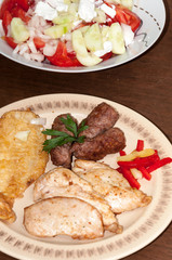 Kebabs in the plate and tomato salad