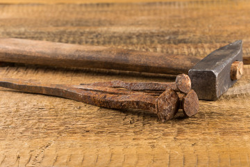Vintage hammer with nails on wood background