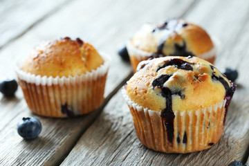 Tasty blueberry muffins on a grey wooden background