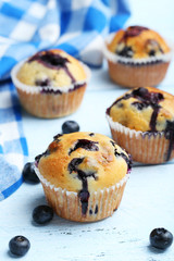 Tasty blueberry muffins on a blue wooden background