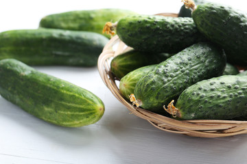 Fresh cucumbers on white wooden background