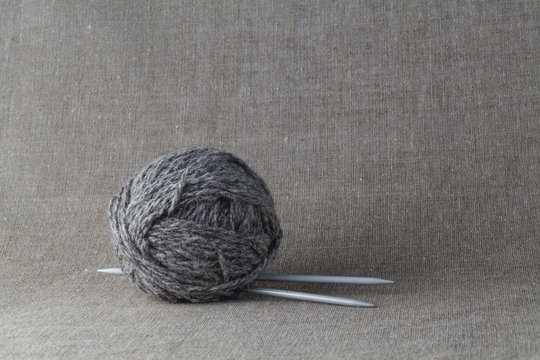 Clew of gray yarn with needle