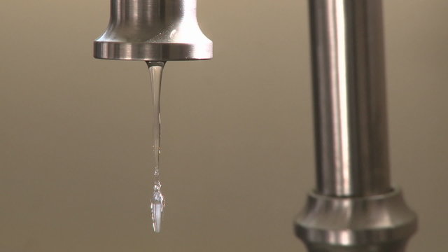 Close up of water dripping fast from a faucet in Oak View, California.