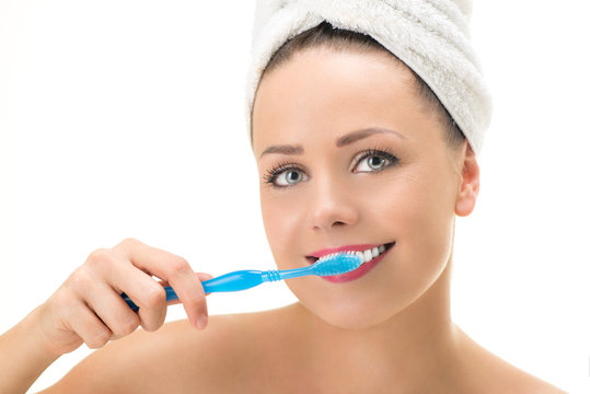 Portrait of Young cute woman brushing her teeth. Looking at camera. Close-up.