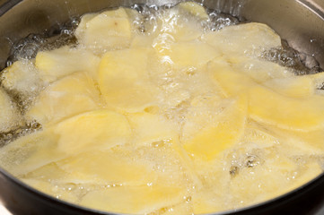 Frying potato chips in deep hot oil